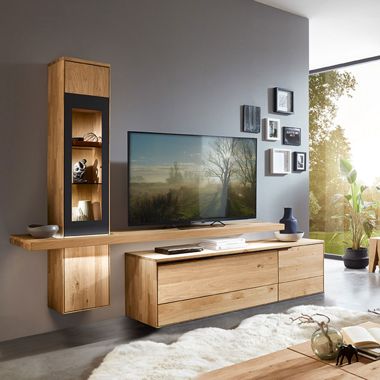 Wohnzimmer Type 0103G bestehend aus einem TV-Hängeelement als Vitrine in Wildeiche und einem mittig angebrachten Board für den Fernseher, kombiniert mit einem Lowboard in Wildeiche.