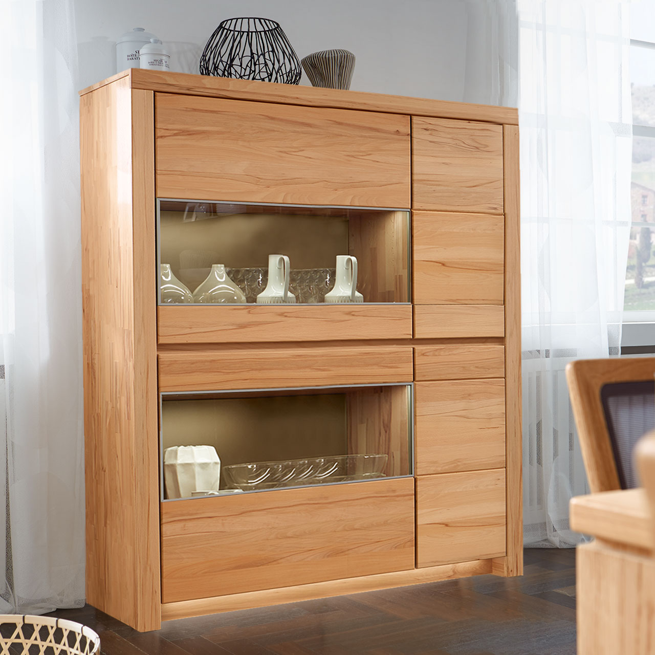 Soleo-3000-Zeilenschrank-4103-ambiente-Kernbuche SOLEO 3000 Zeilenschrank Type 4103 in massiver Kernbuche, mit zwei schalen Holztüren und zwei breiten Türen mit Vitrinenfach untereinander angeordnet, als Ambiente Bild.