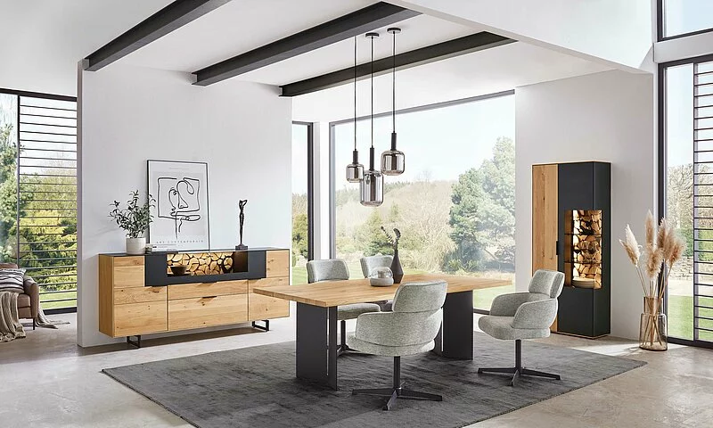 Banner zeigt Metall Wangentisch mit Wildeiche Massivholz Tischplatte, dazu passende bequeme ergonomische Polsterstühle in hellgrau, 360 Grad drehbar mit Metallgestell.