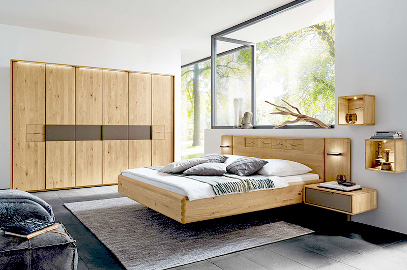 Schlafzimmer WSM 1600  Hier werden Sie zu der Schlafzimmer Serie WSM 1600 weitergeleitet: Kachel zeigt Wildeiche Schlafzimmer, Doppelbett, zwei Konsolen und Paneelaufsatz, Kombiniert mit einem 6 türigen Kleiderschrank mit Mattglas Banderole und Hirnholz Akzenten.