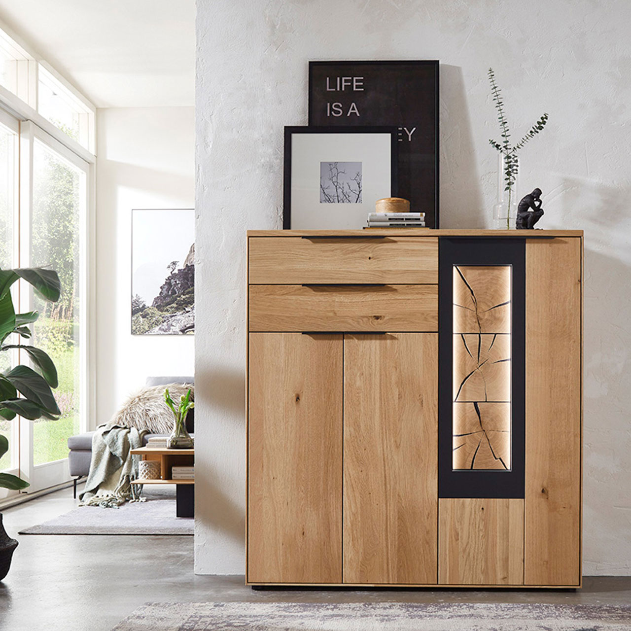 WM-1910-Highboard-4253-Ambiente Modernes Highboard aus Wildeiche mit rechtem abgesetzten Akzent mit carbonfarbigen Metallrahmen und Hirnholz, als Ambiente Bild.