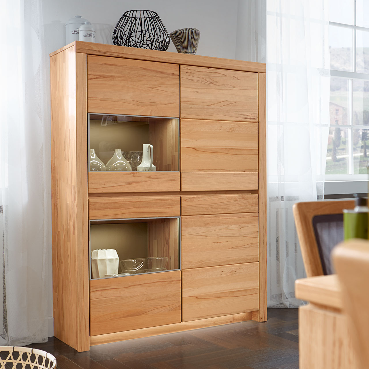 Soleo-3000-Zeilenschrank-4903-ambiente-Kernbuche SOLEO 3000 Zeilenschrank Type 4903 in massiver Kernbuche, mit zwei Holztüren und zwei Türen mit Vitrinenfach untereinander angeordnet, als Ambiente Bild.