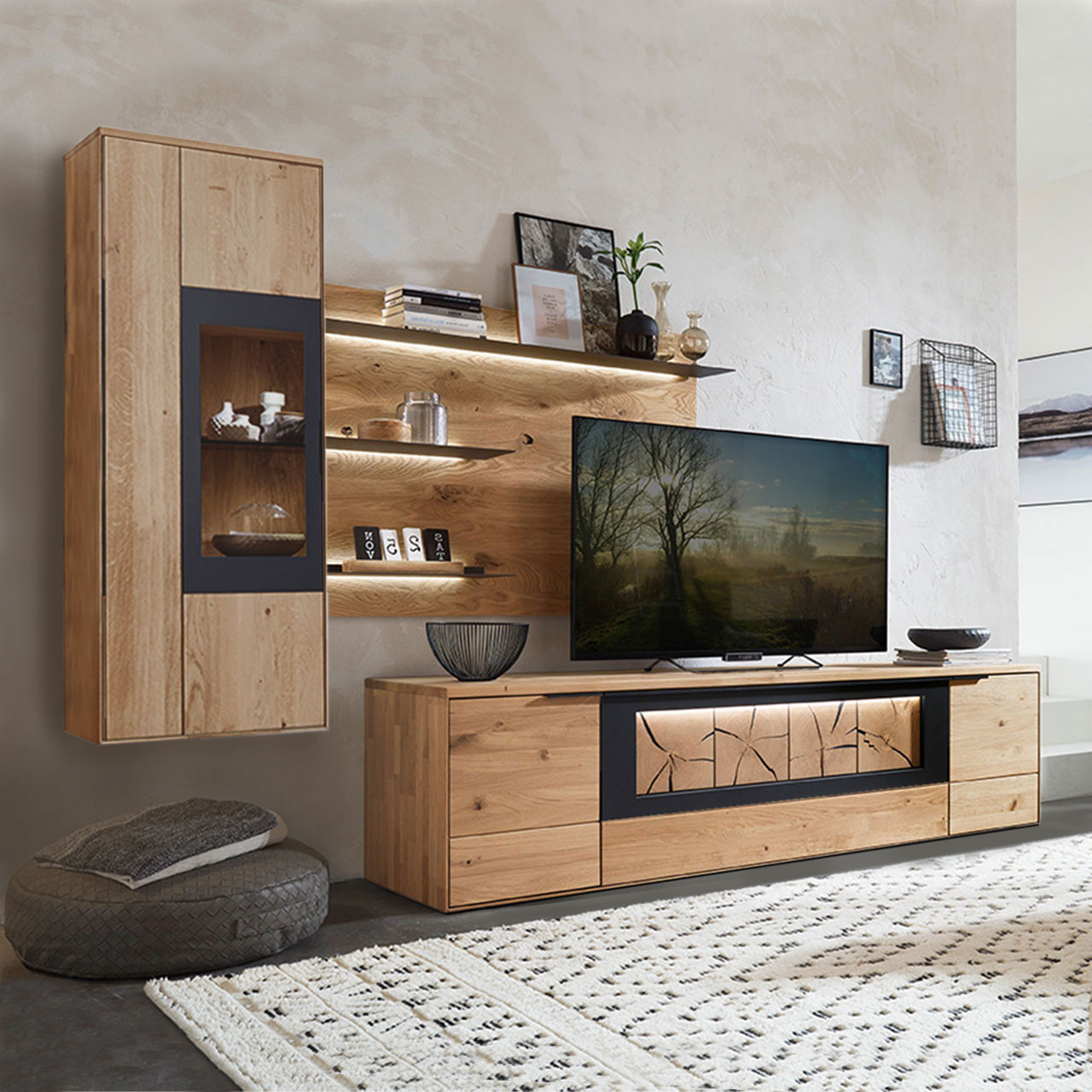 Wohnzimmer Type 0106G, bestehend aus einer Hängevitrine in Wildeiche mit einem carbonfarbigen Metallrahmen, kombiniert mit einem Wandboard und einem Lowboard, in Wildeiche und Hirnholz Akzent.
