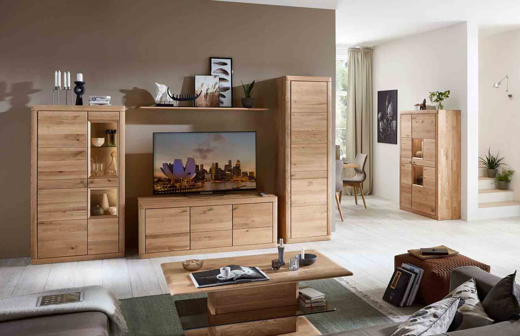 Wohnzimmer Aurum Hier werden Sie zur Aurum Kategorie weitergeleitet. Kachel zeigt Wohnwand in Wildeiche als 3-teilige Kombination, bestehend aus ein Lowboard, Highboard mit Vitrinenfach einem Zeilenschrank mit Holztür als Stauraum.