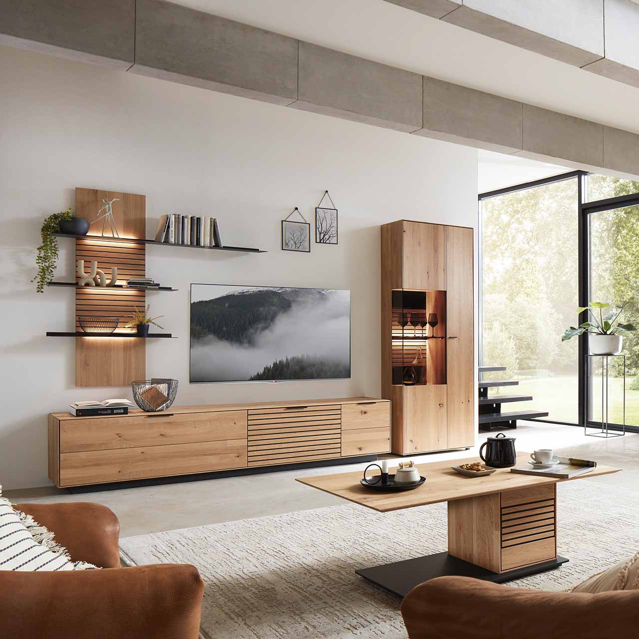 WM2320-Zeilenschrank-6743-Erle-Ambiente WM 2320 - Zeilenschrank 6744 in Wildeiche, mit Vitrinenfach, Rückwand in Lamellen und schwarzem Mattglas Akzent. Abgebildet in einer Wohnwand Kombination.