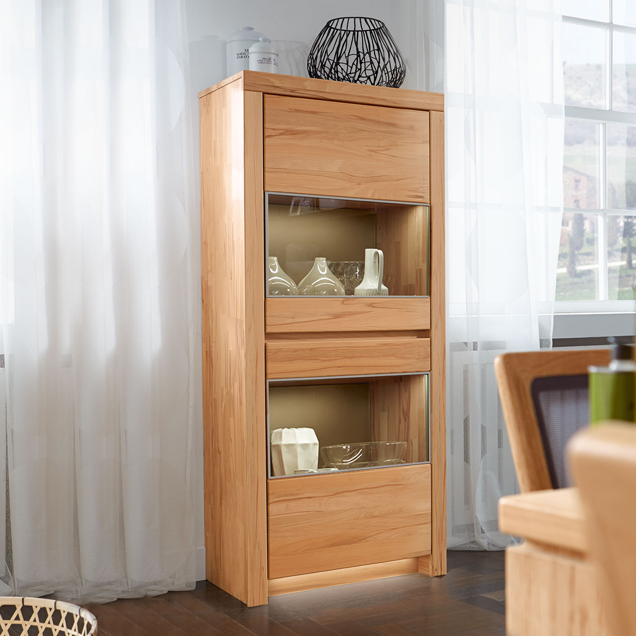 Soleo-3000-Zeilenschrank-47034-ambiente-Kernbuche SOLEO 3000 schmaler Zeilenschrank Type 4703 in massiver Kernbuche, mit zwei Holztüren mit jeweiligen Vitrinenfach, untereinander angeordnet, es sind 3 Einlegeböden inklusive, als Ambiente Bild.