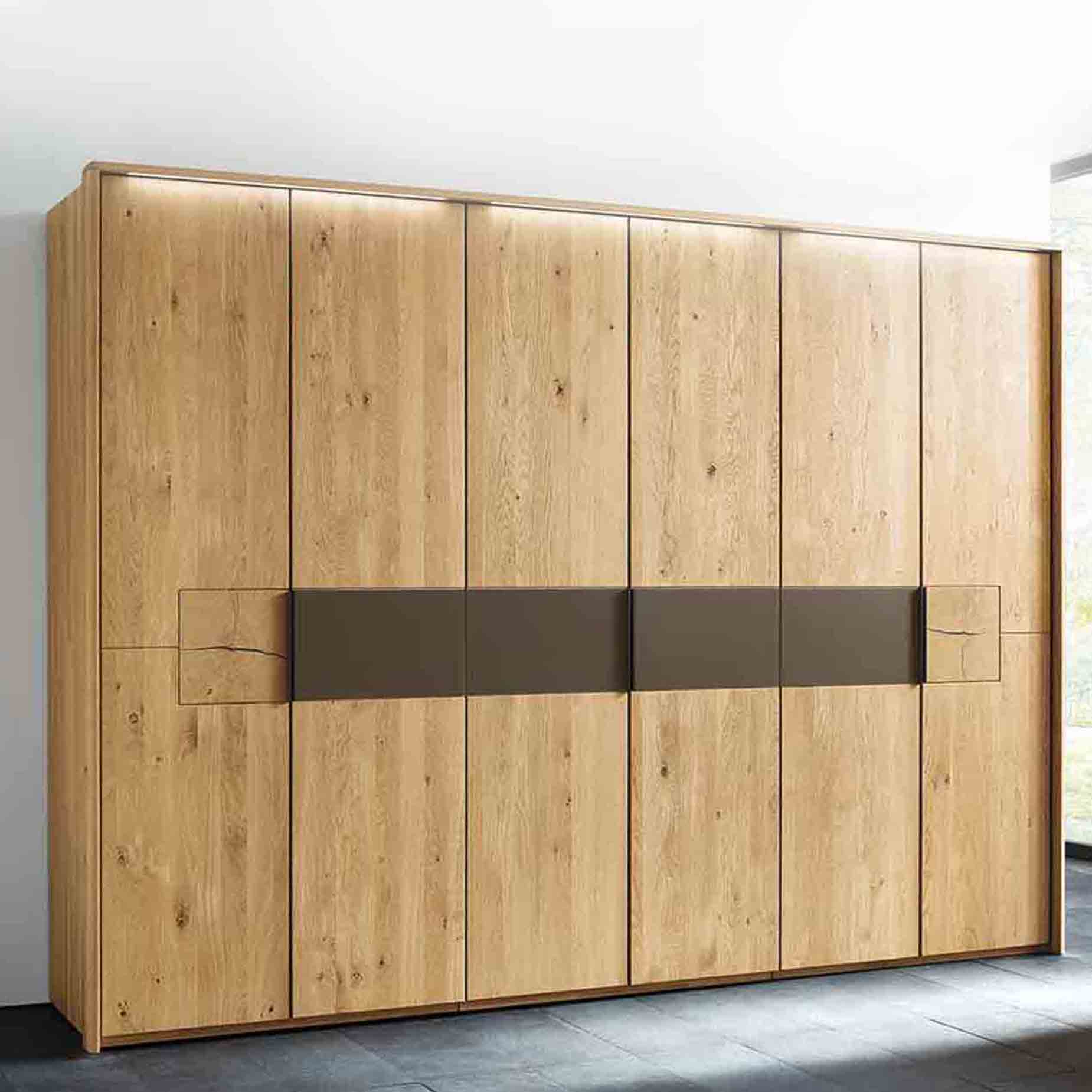 Drehtürenschrank 2-türig bis 7-türig, in Wildeiche massiv mit Mattglas cubanit Akzent banderole mittig und Hirnholz Applikation.