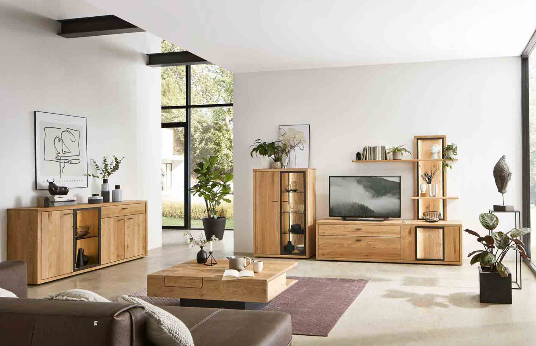 Wohnzimmer Programm WM 2250 Hier werden Sie zur WM 2250 Kategorie weitergeleitet. Kachel zeigt modernes 3-teiliges Wohnzimmer in Wildeiche, bestehend aus ein Higfhboard mit Vitrinenfach, umrahmt mit Metallrahmen und Spalteiche Rückwand, Lowboard und Paneele mit zwei Holzablagen..