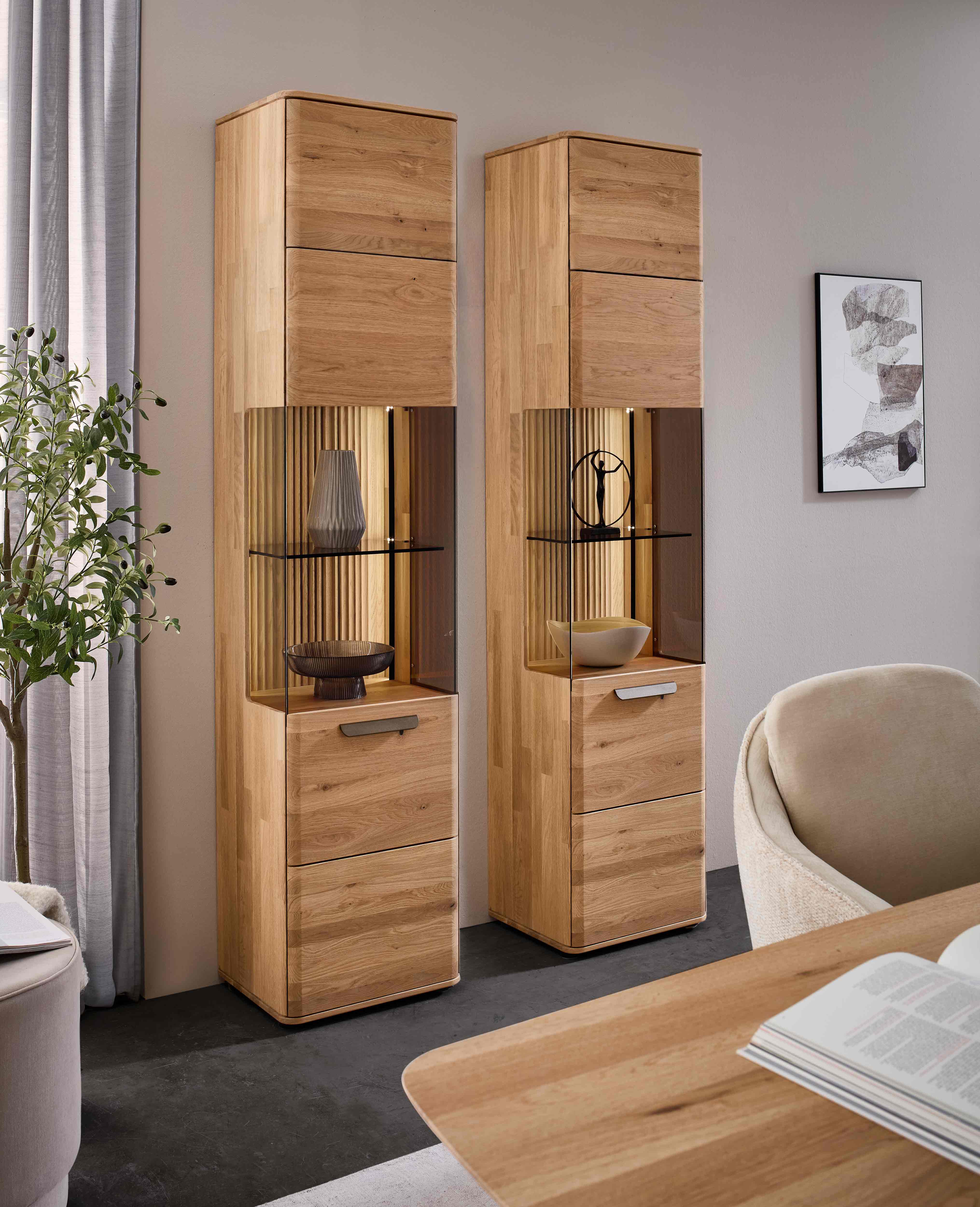 WM 2620 Vitrinen Zeilenschrank mit Wildeiche Flow Rückwand und LED-Beleuchtung.