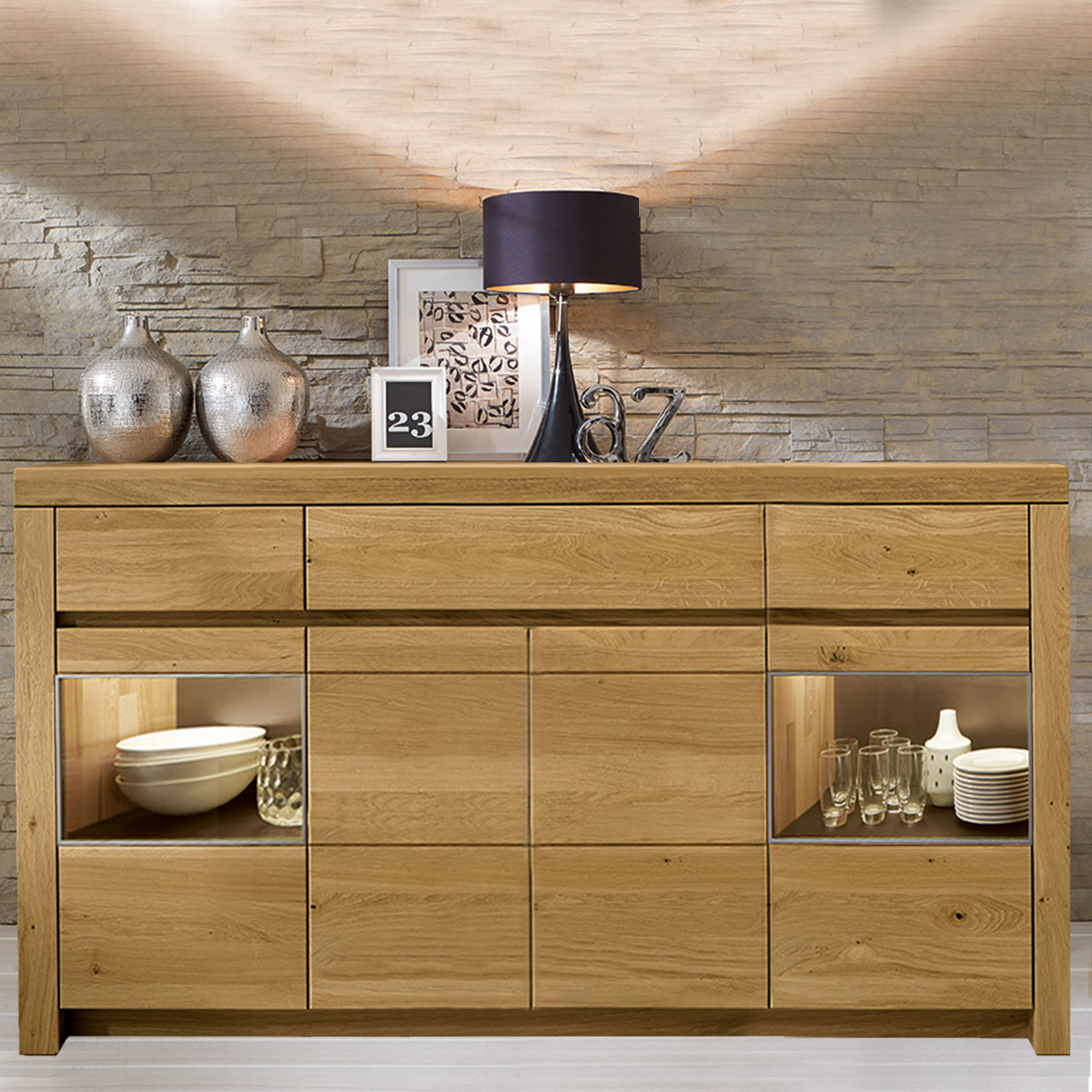Soleo-3000-Sideboard-3140-ambiente-wildeiche Sideboard in massiver Wildeiche Type 3140 mit drei Schubkästen und zwei Holztüren mittig, zwei Türen mit Vitrinenfach, als Ambiente Bild.