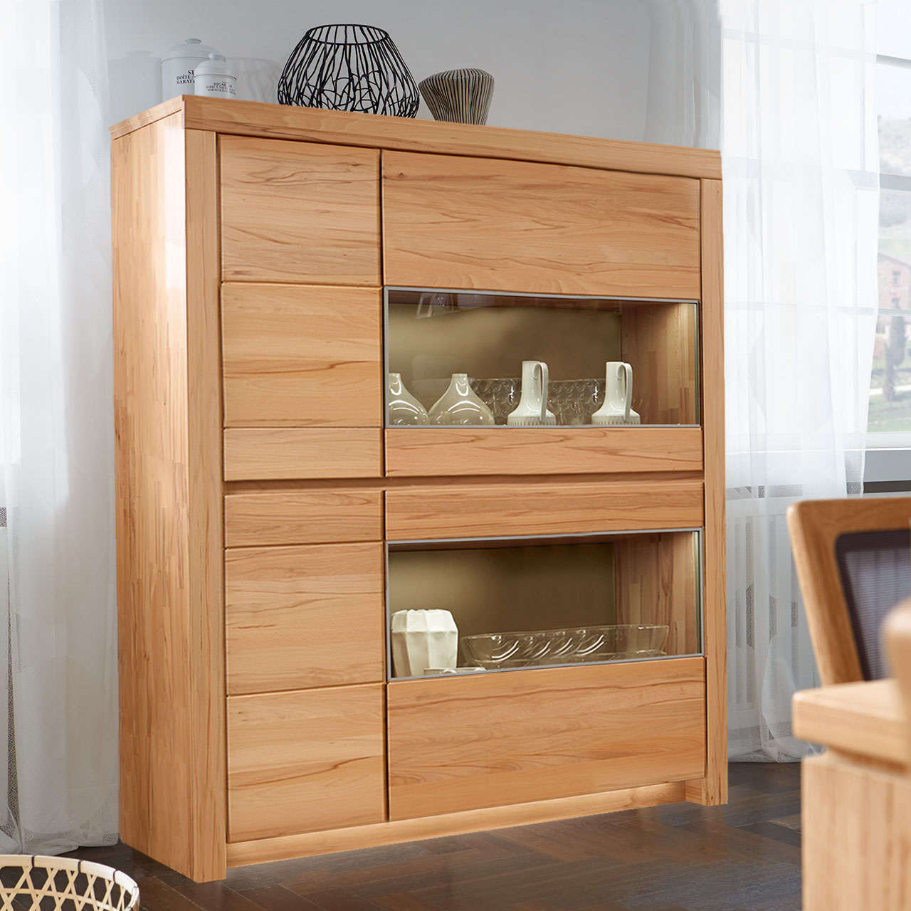 Soleo-3000-Zeilenschrank-4104-ambiente-Kernbuche SOLEO 3000 Zeilenschrank Type 4104 in massiver Kernbuche, mit zwei schalen Holztüren und zwei breiten Türen mit Vitrinenfach untereinander angeordnet, als Ambiente Bild.